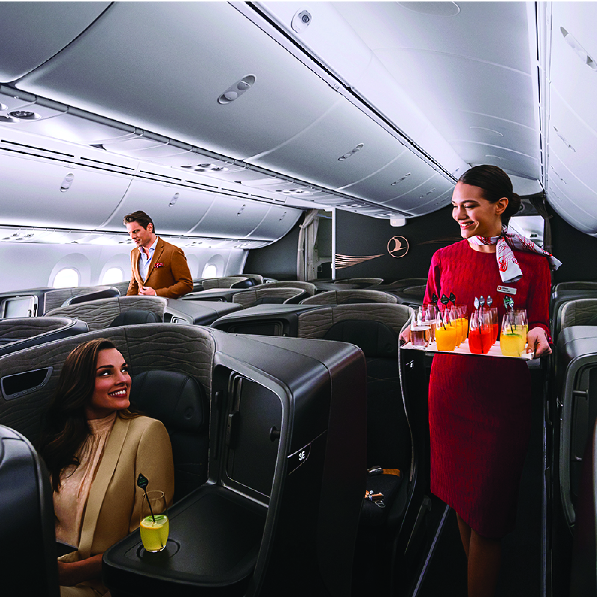 Flight attendant serving drinks in first class cabin