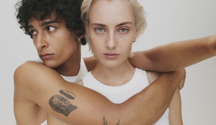 Two people embracing, intense gaze, white tops