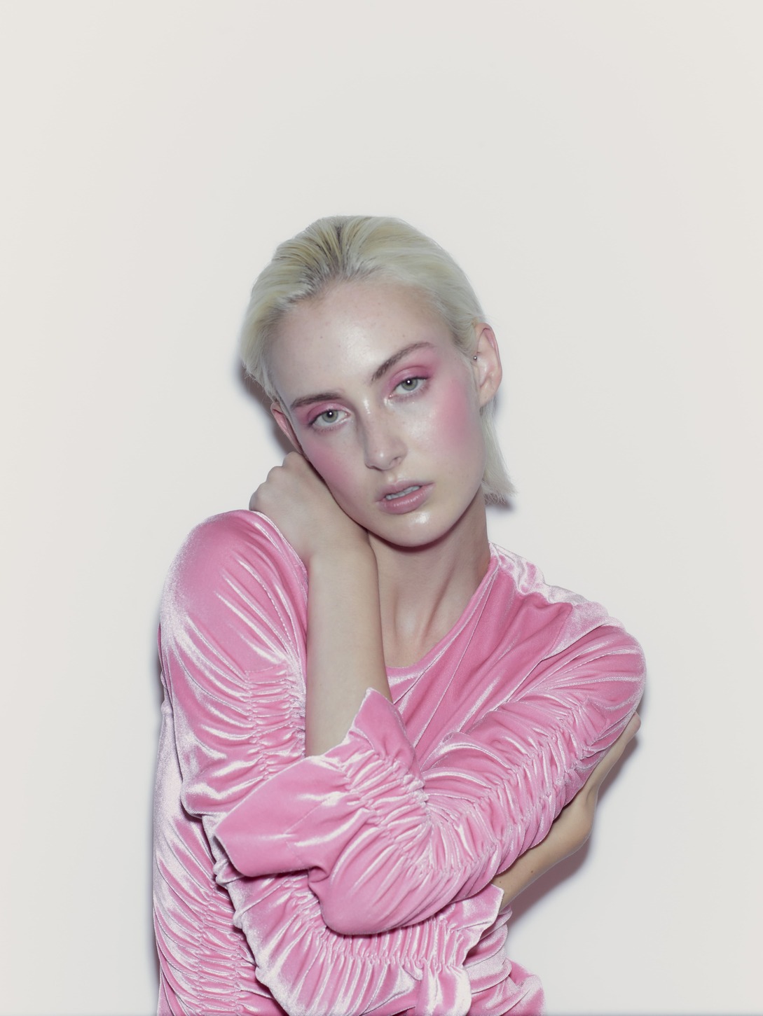 Person in pink velvet top with pink eye makeup