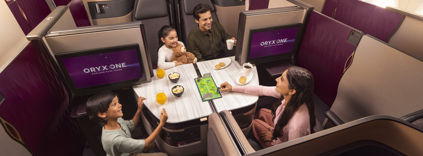 Family enjoying drinks and games in airplane suite