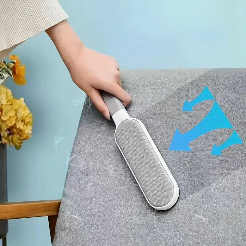Hand using lint remover brush on fabric surface