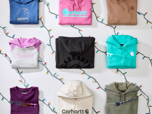 Nine folded Carhartt hoodies with string lights