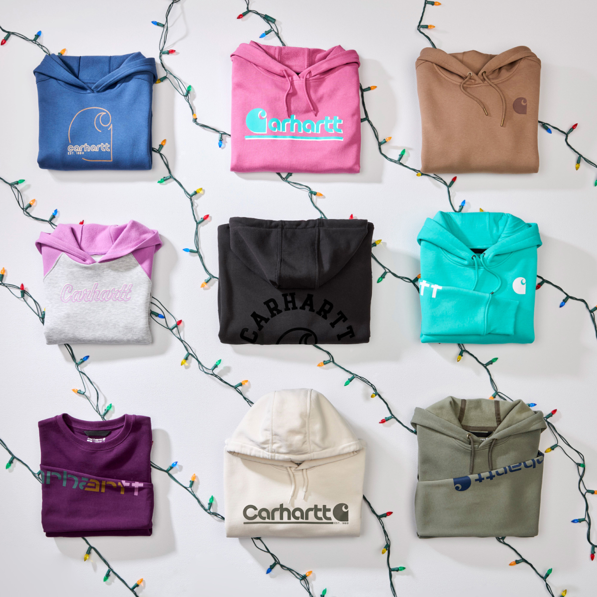 Nine folded Carhartt hoodies with string lights