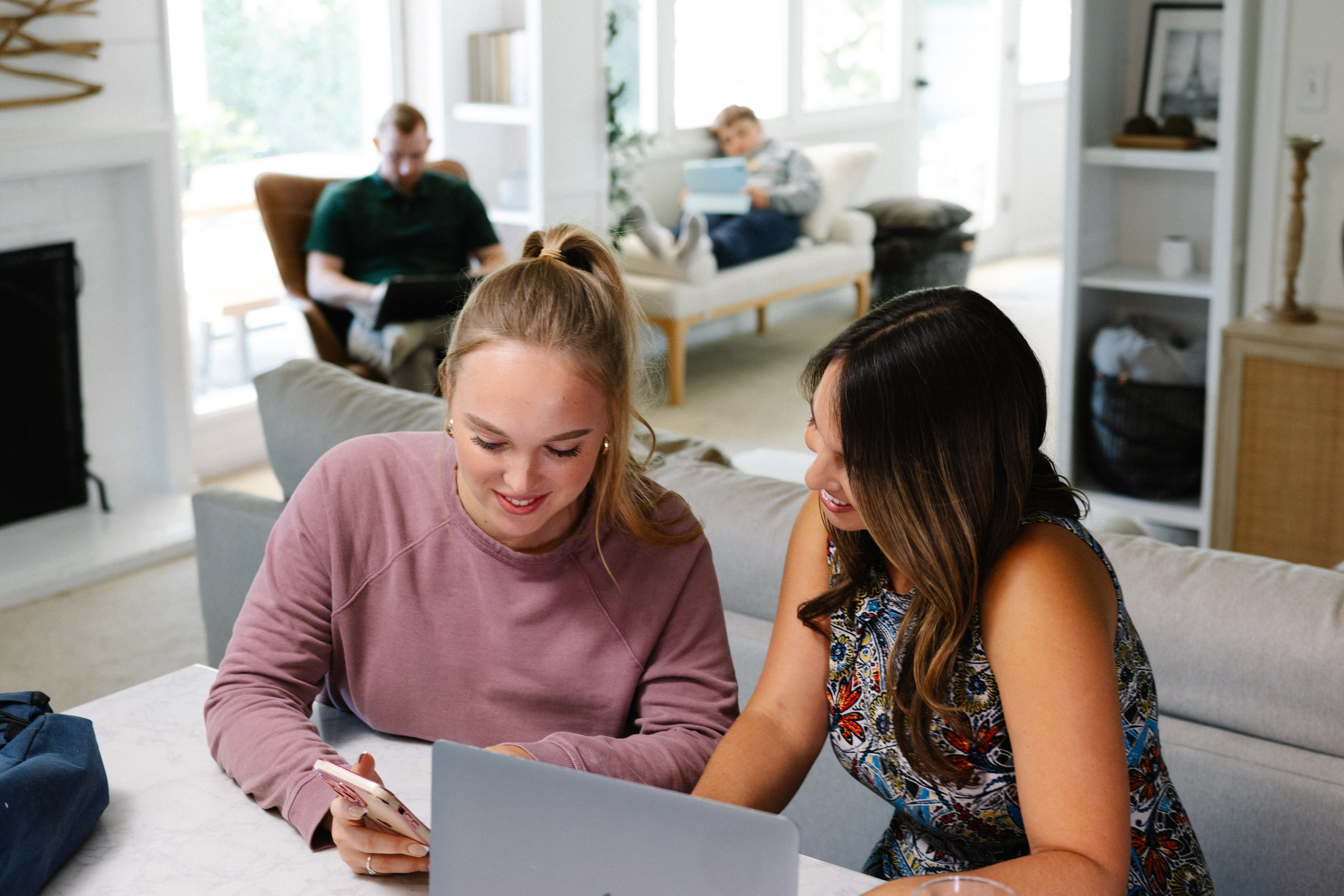 Two women collaborating with laptop in cozy living room