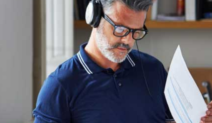 Man wearing headphones reviewing documents in office