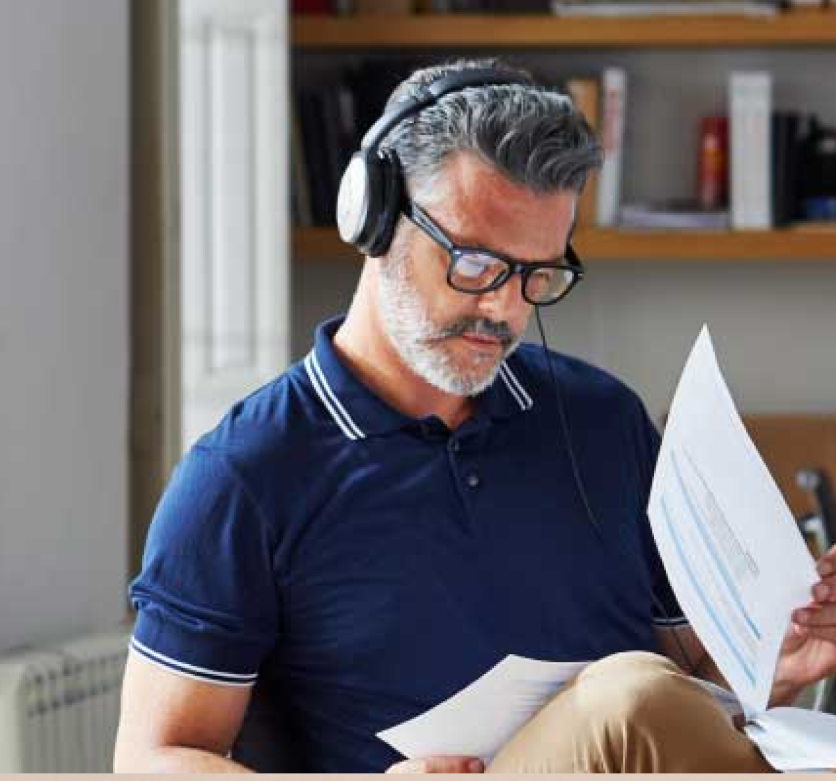 Man wearing headphones reviewing documents in office