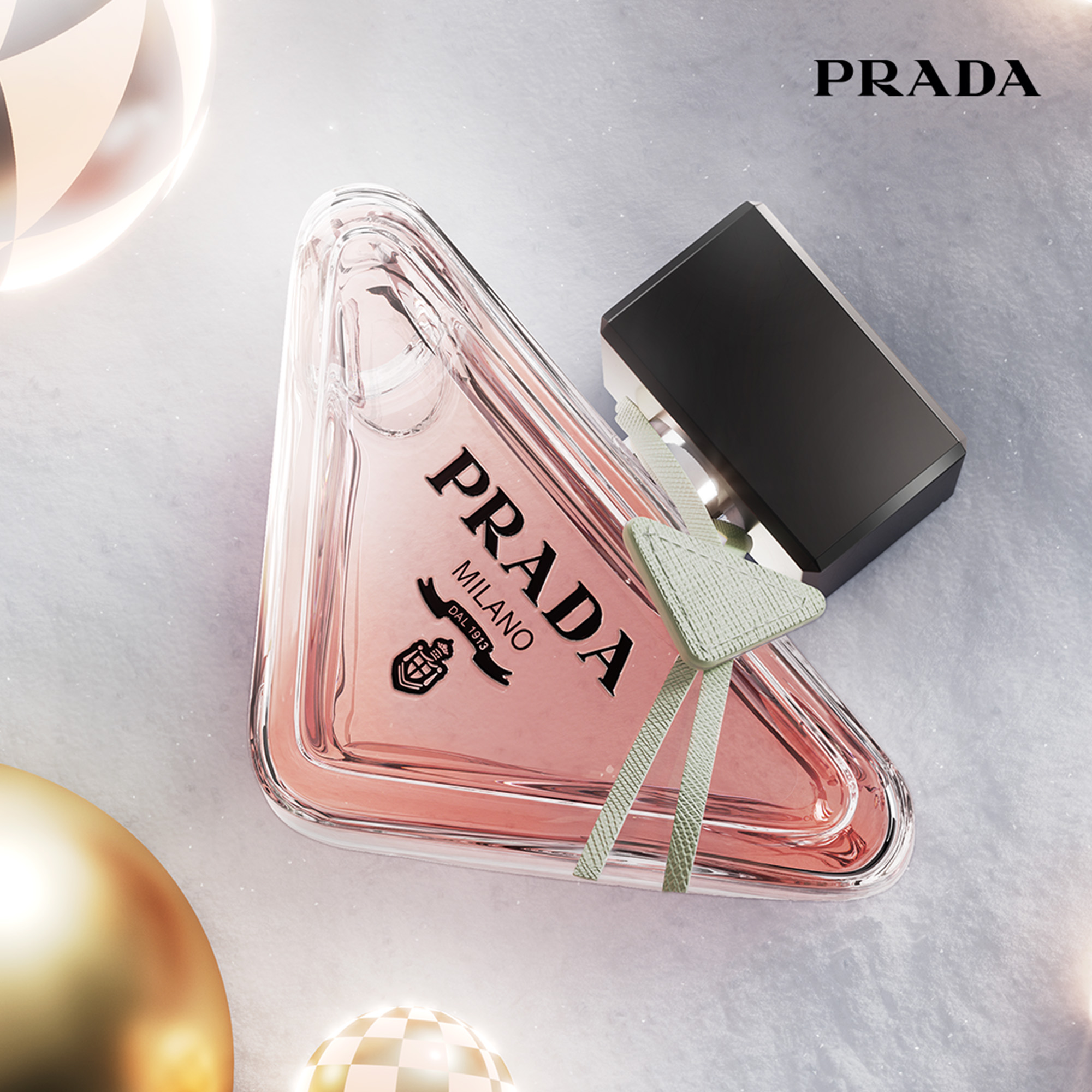 Triangular pink Prada perfume bottle with black cap