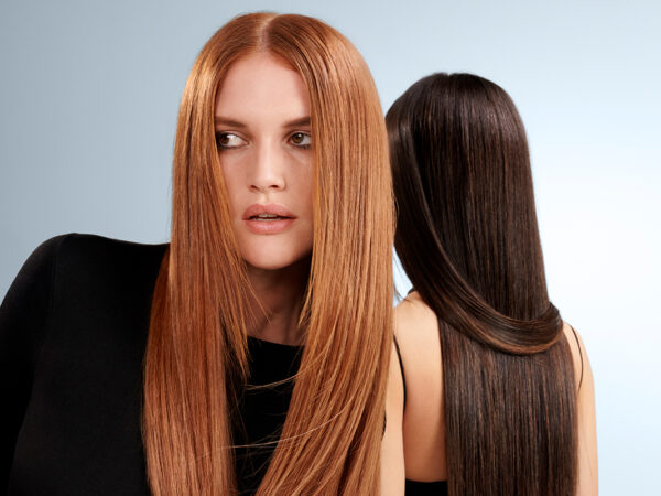 Two women with long straight red and black hair