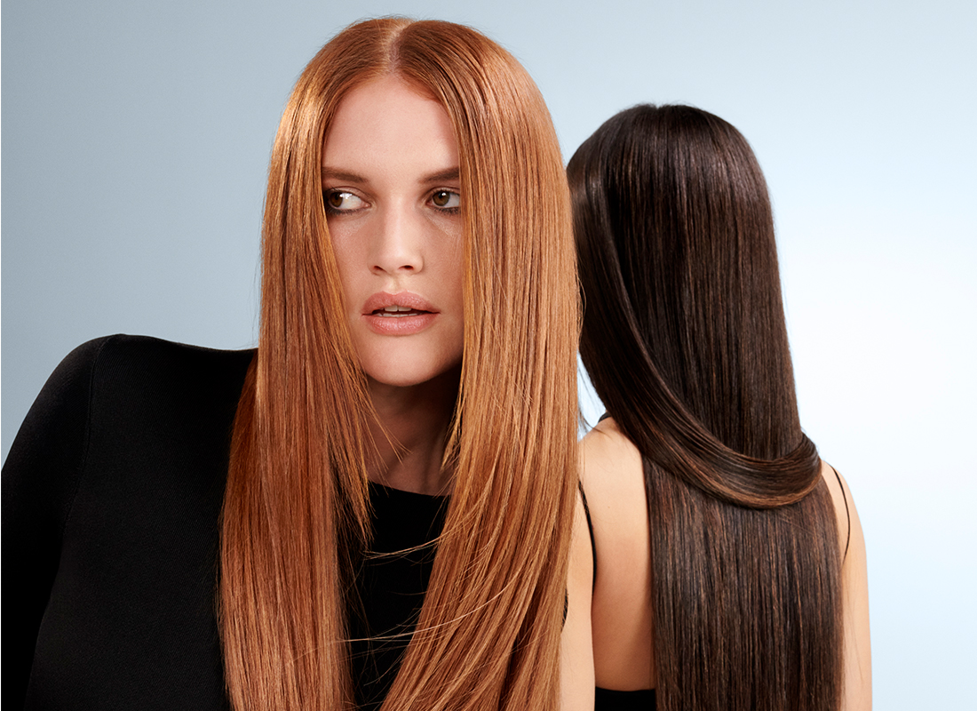 Two women with long straight red and black hair