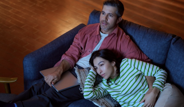 Couple relaxing together on blue couch indoors
