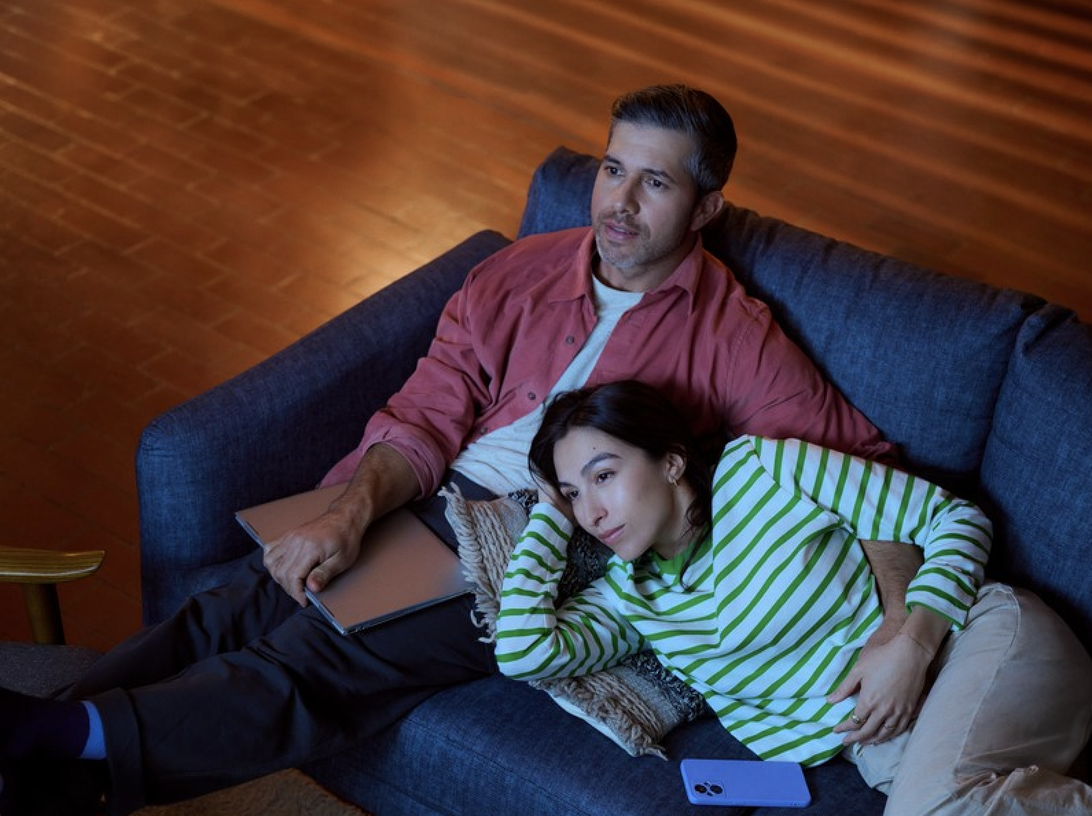 Couple relaxing together on blue couch indoors