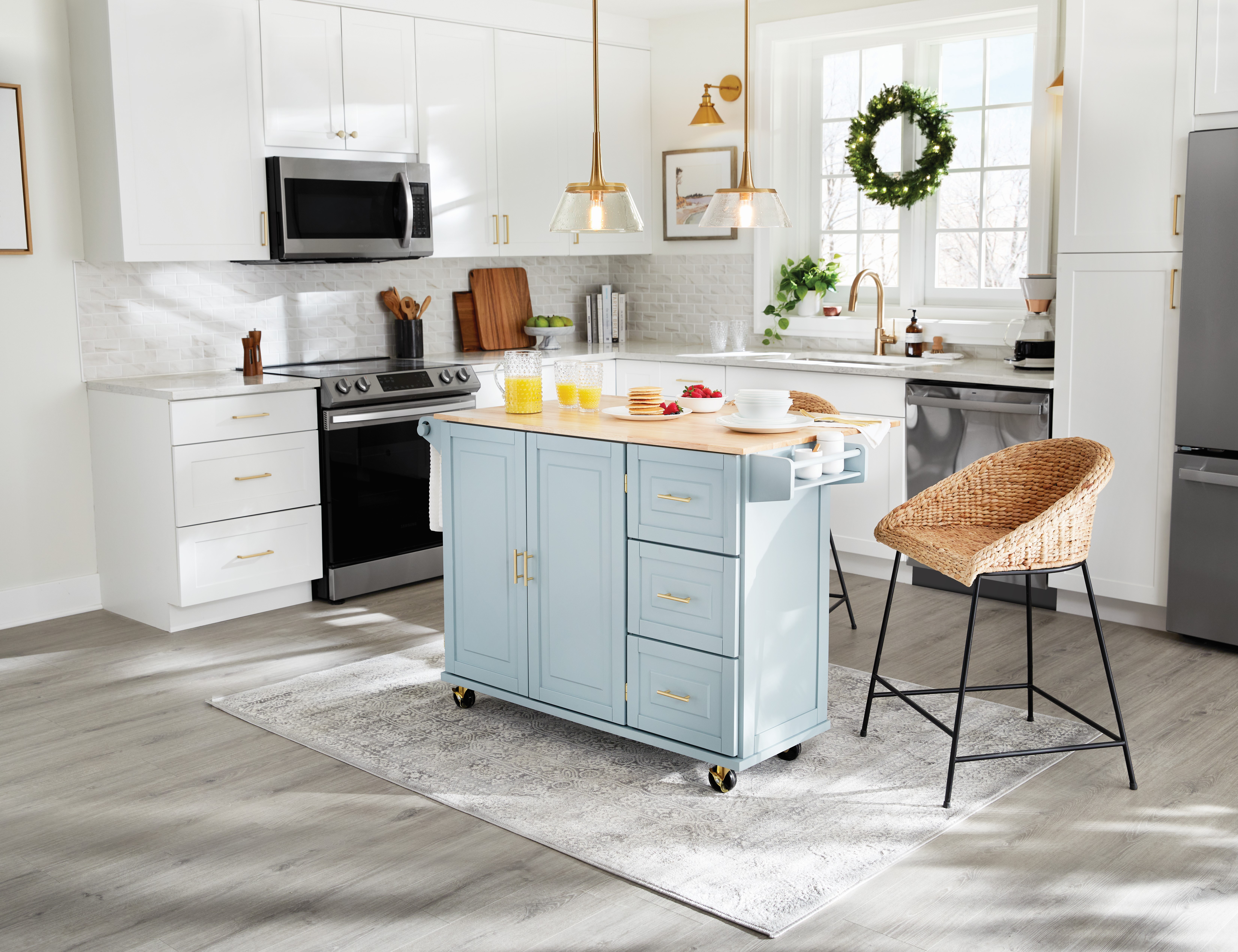 Bright kitchen with blue island, wicker chair