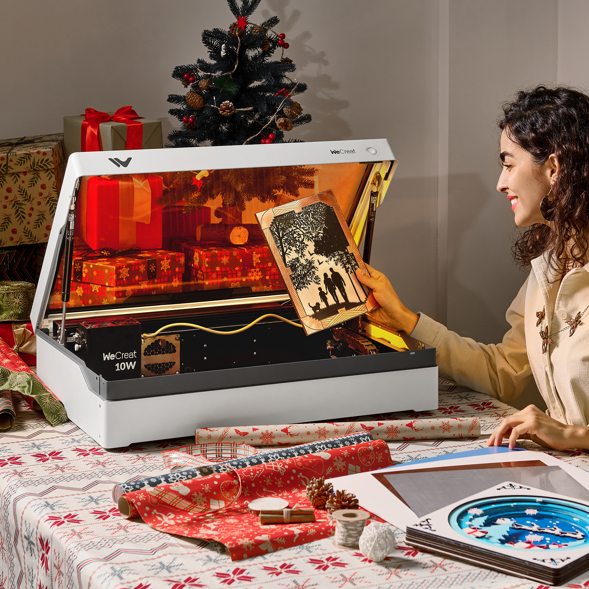 Woman holding laser-cut wood art near laser engraving machine