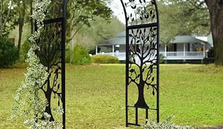 Black metal garden arch with tree design and vines
