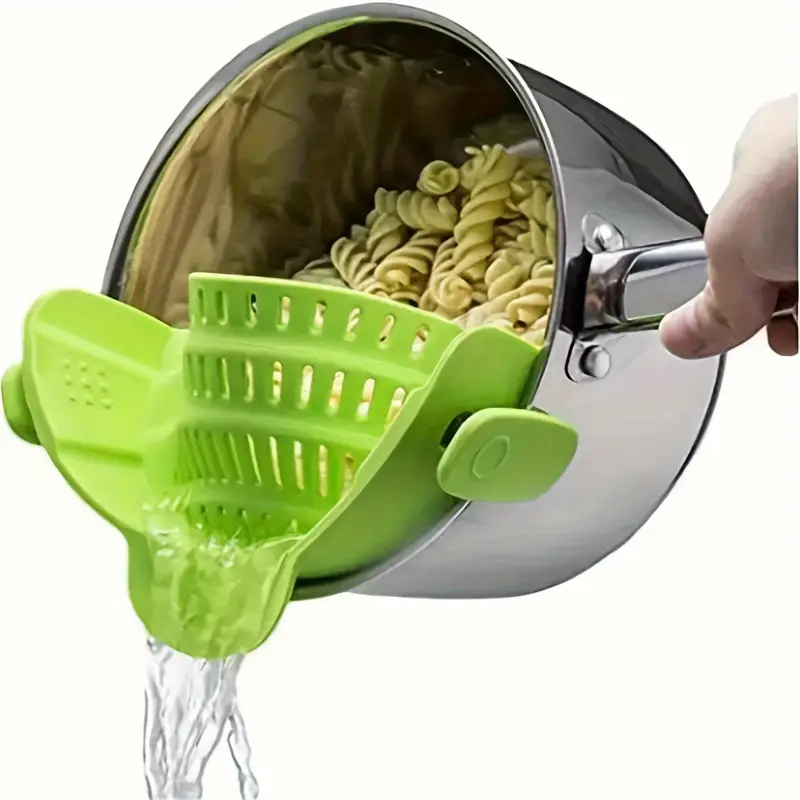Green strainer draining pasta in pot