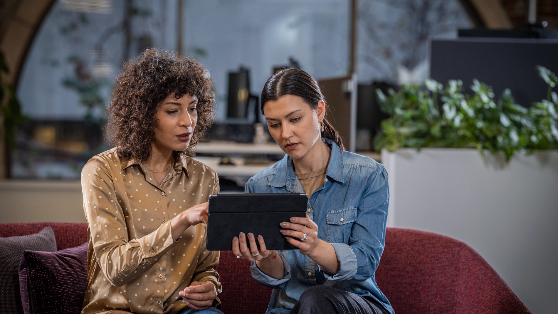 Two women looking at a tablet together indoors