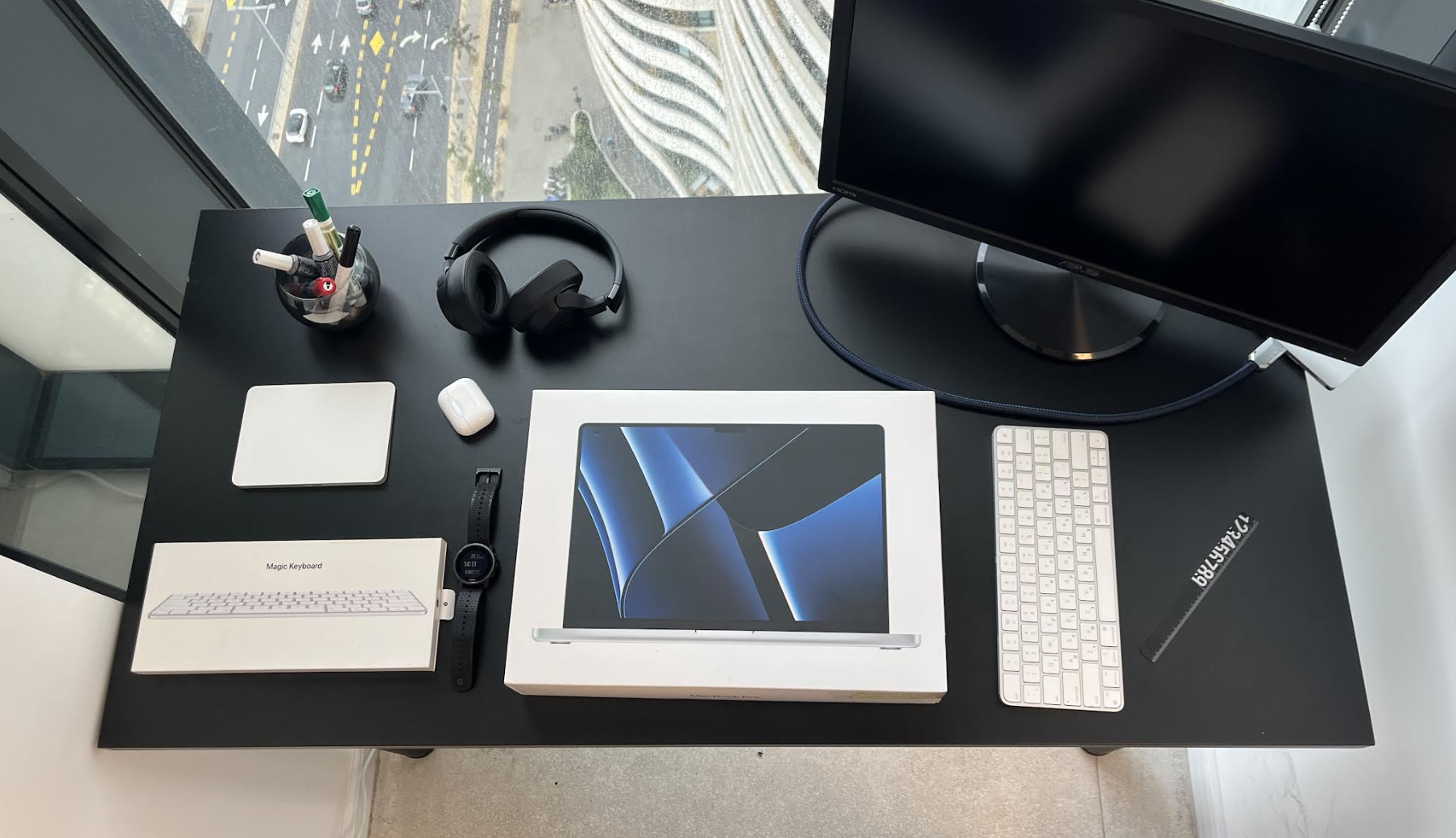 Black desk with Apple devices and accessories