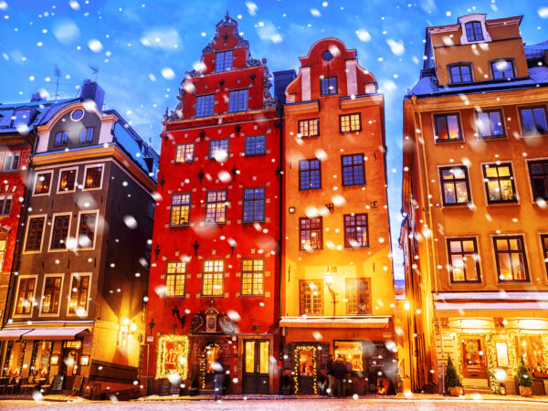 Snowfall on colorful historic buildings at dusk