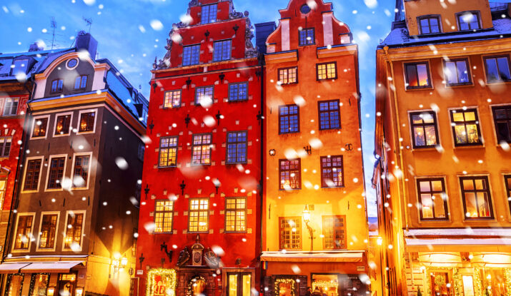 Snowfall on colorful historic buildings at dusk