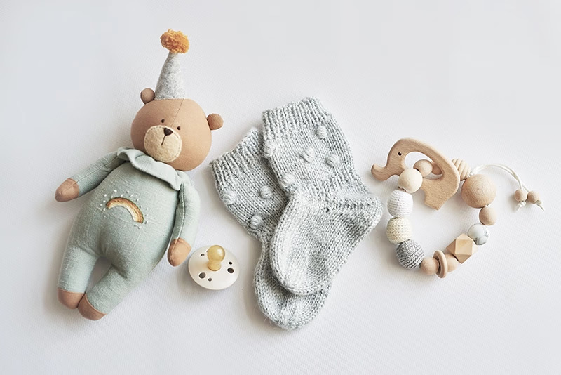 Baby toys, socks, pacifier on white background