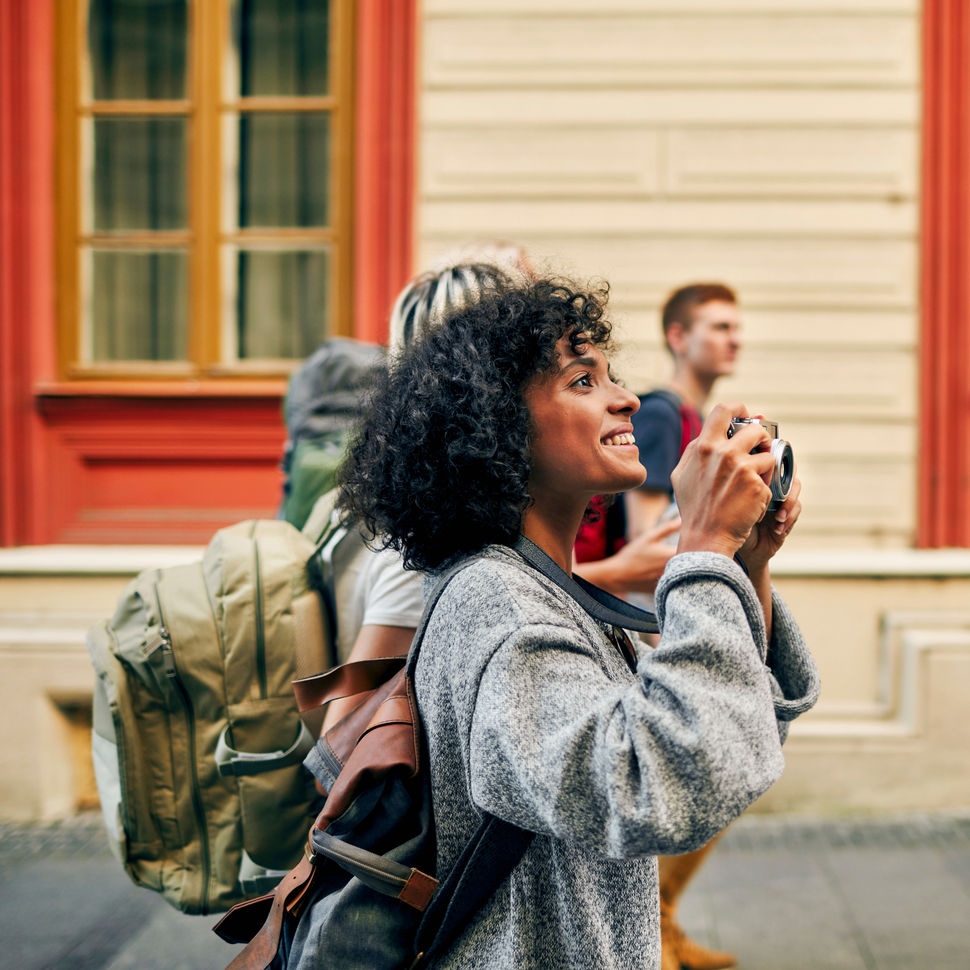 Smiling woman tourist taking photos with camera