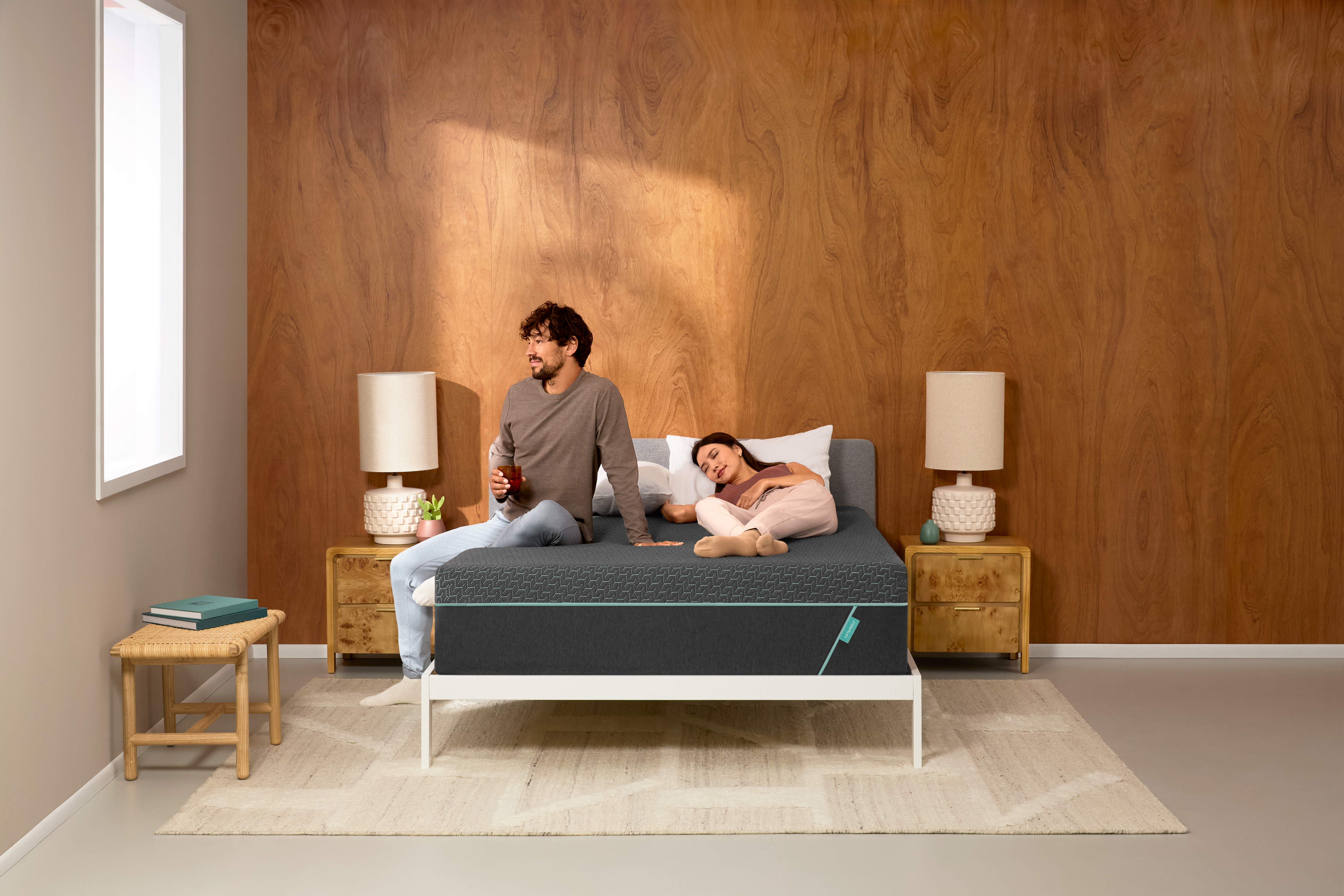 Couple on bed in modern wooden-walled bedroom