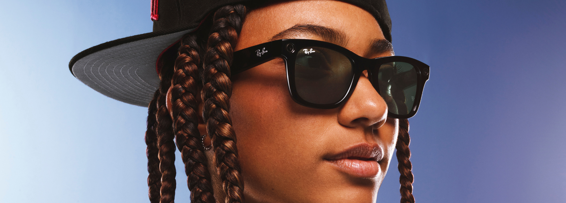Person wearing sunglasses, cap, and braided hair