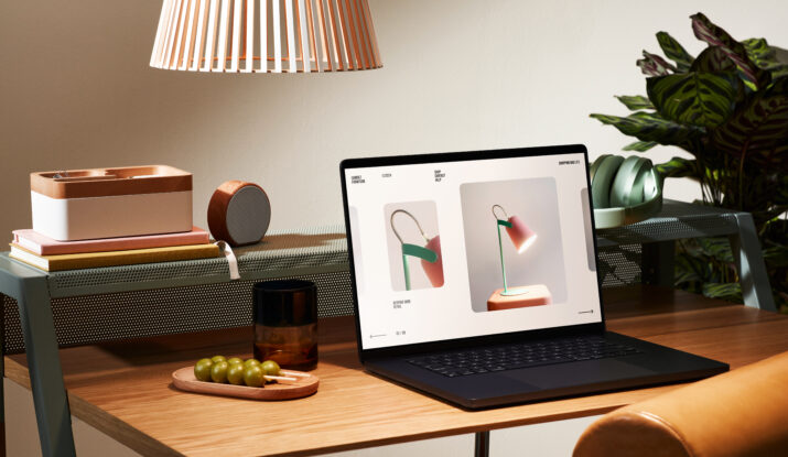 Laptop on wooden desk with lamp and plants