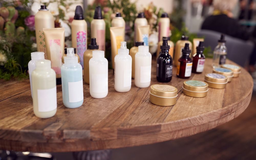 Various cosmetic bottles and containers on wooden table