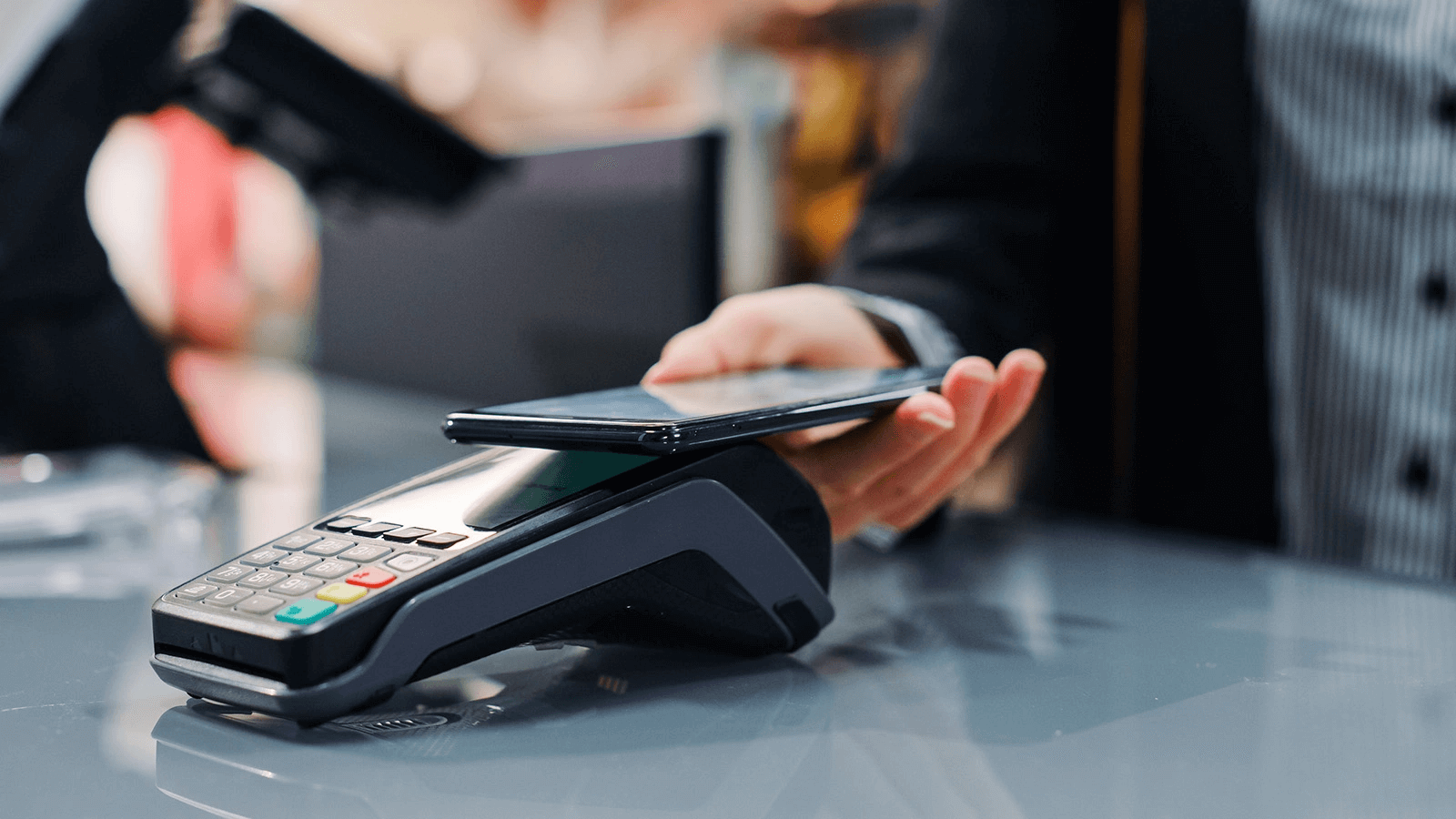 Person making payment with smartphone on terminal
