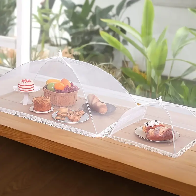 Food covered with mesh food tents on wooden table