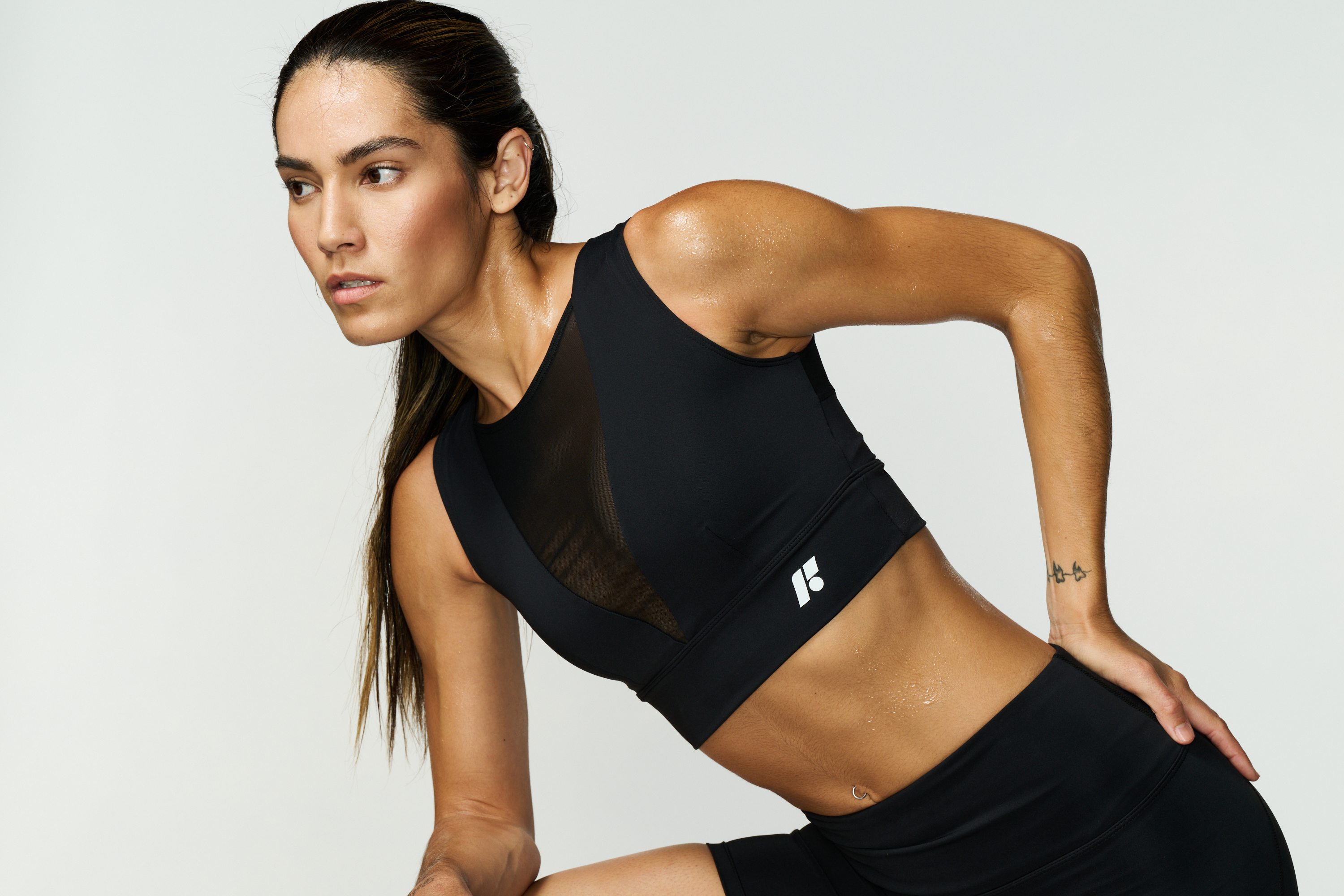 Fit woman in black workout wear leaning forward