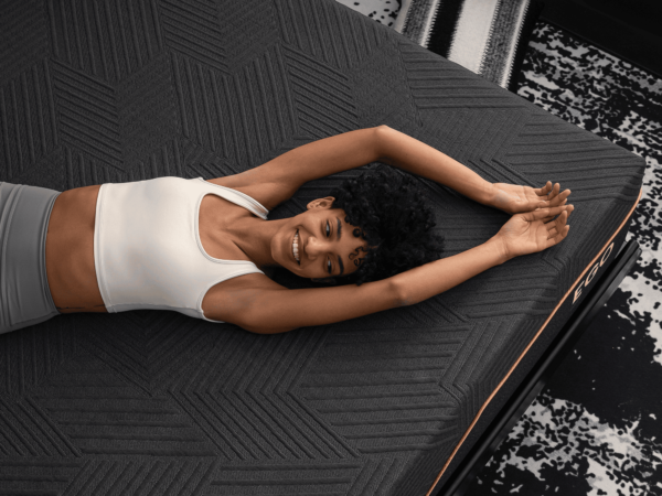 Happy woman stretching on textured black mattress