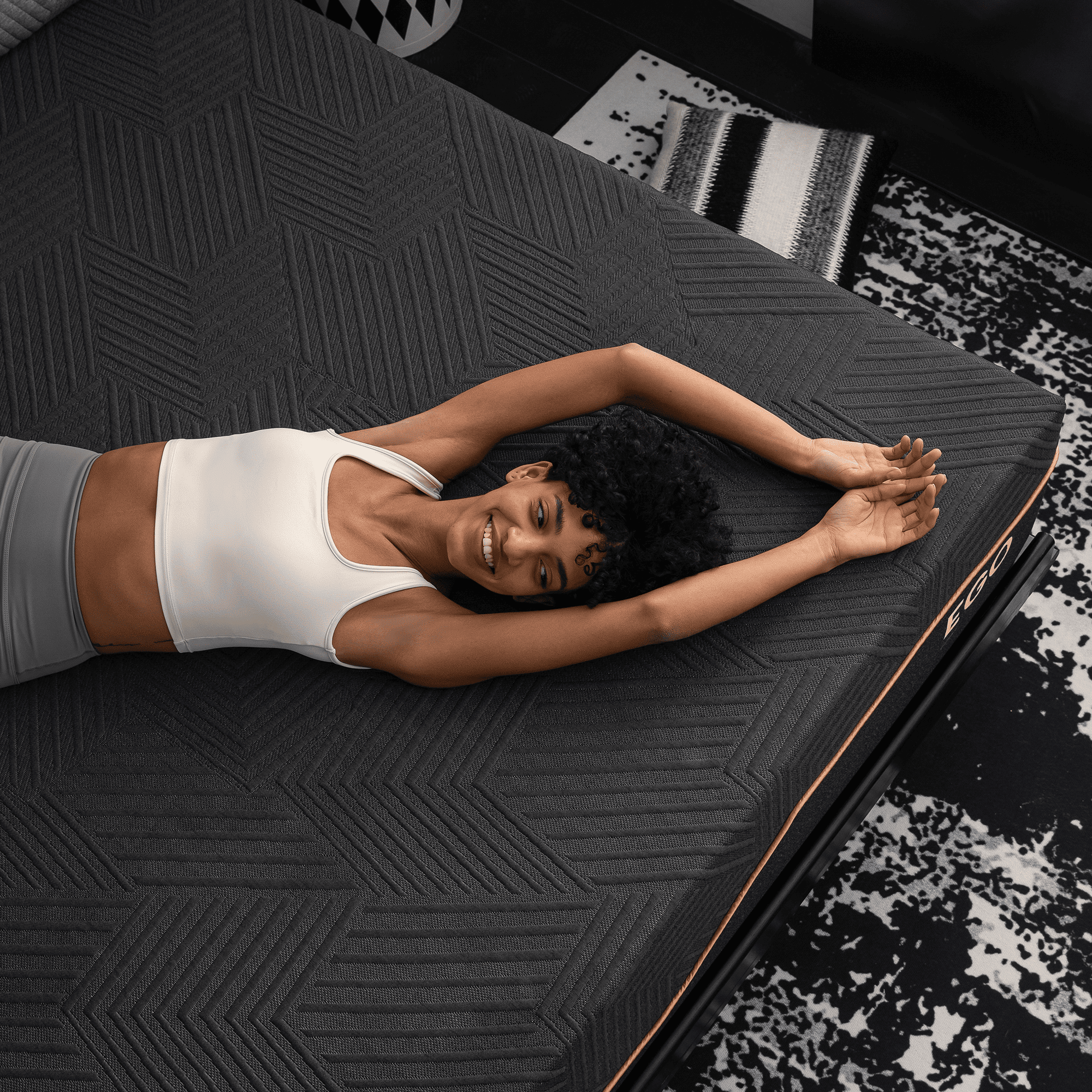 Happy woman stretching on textured black mattress