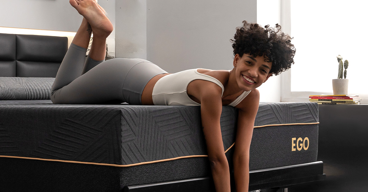 Smiling woman in workout clothes on EGO mattress