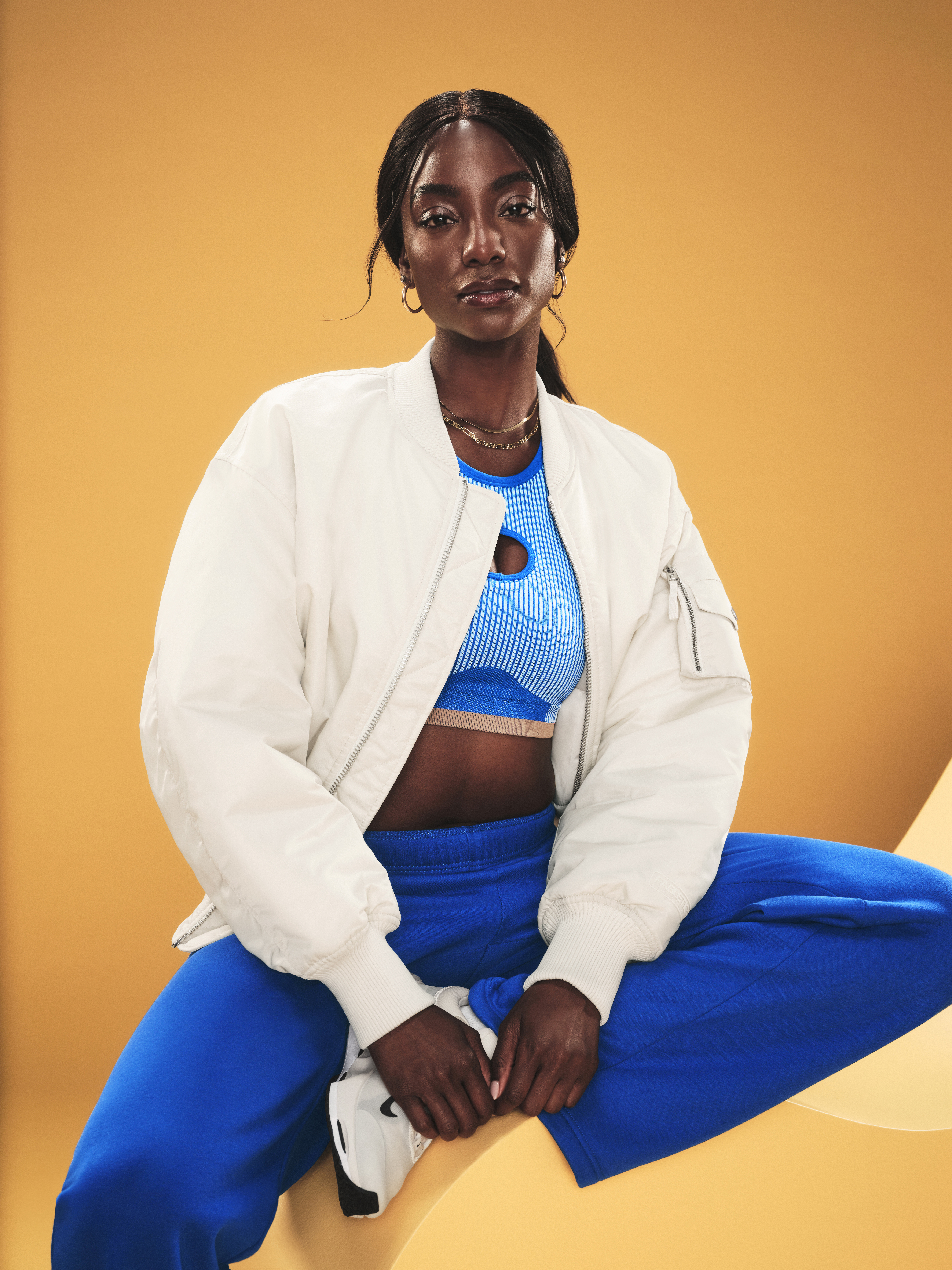 Woman in white jacket and blue athletic wear