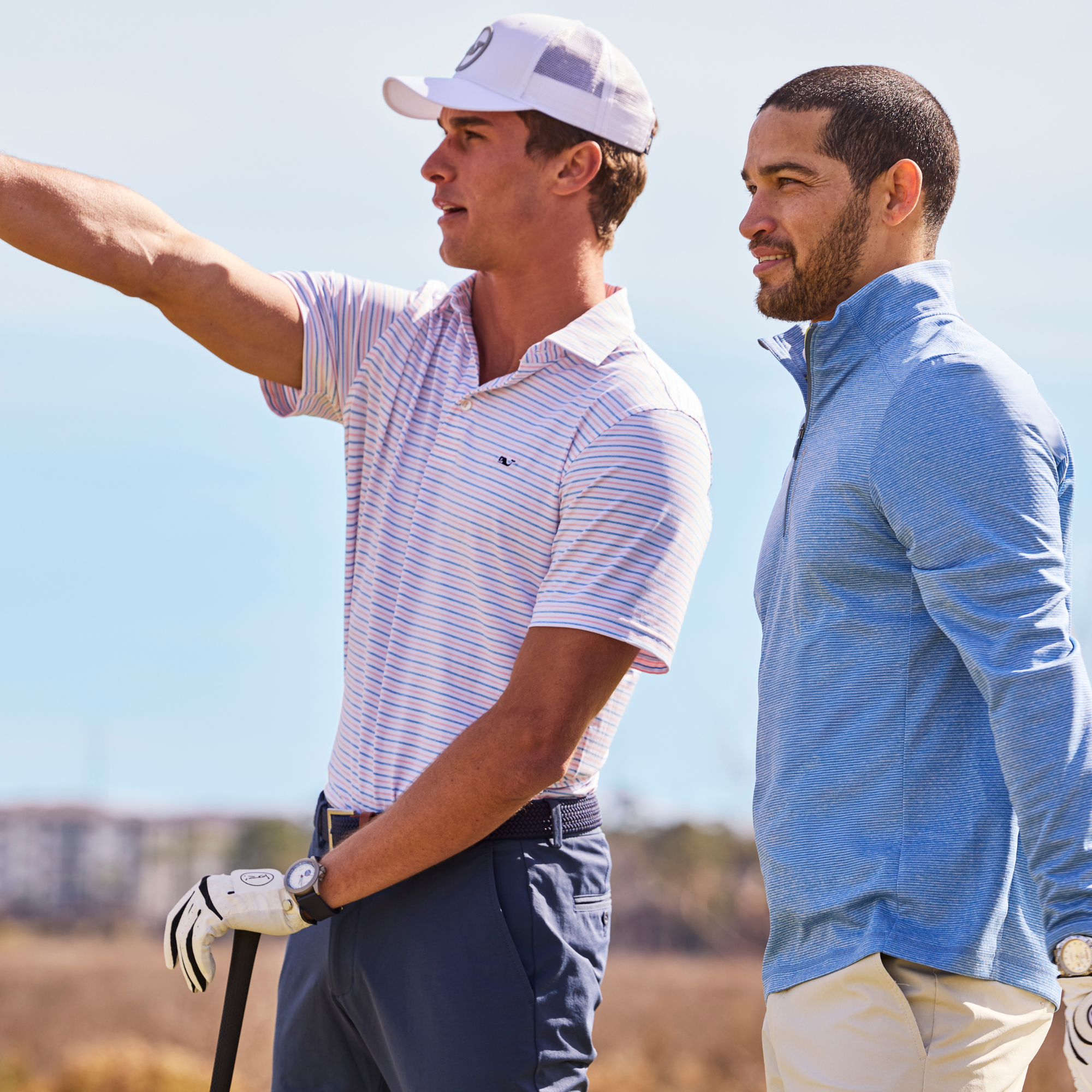 Two men watching and pointing during golf game