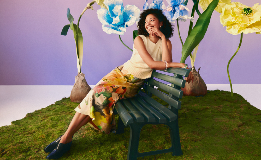 Woman sitting on bench with oversized flowers