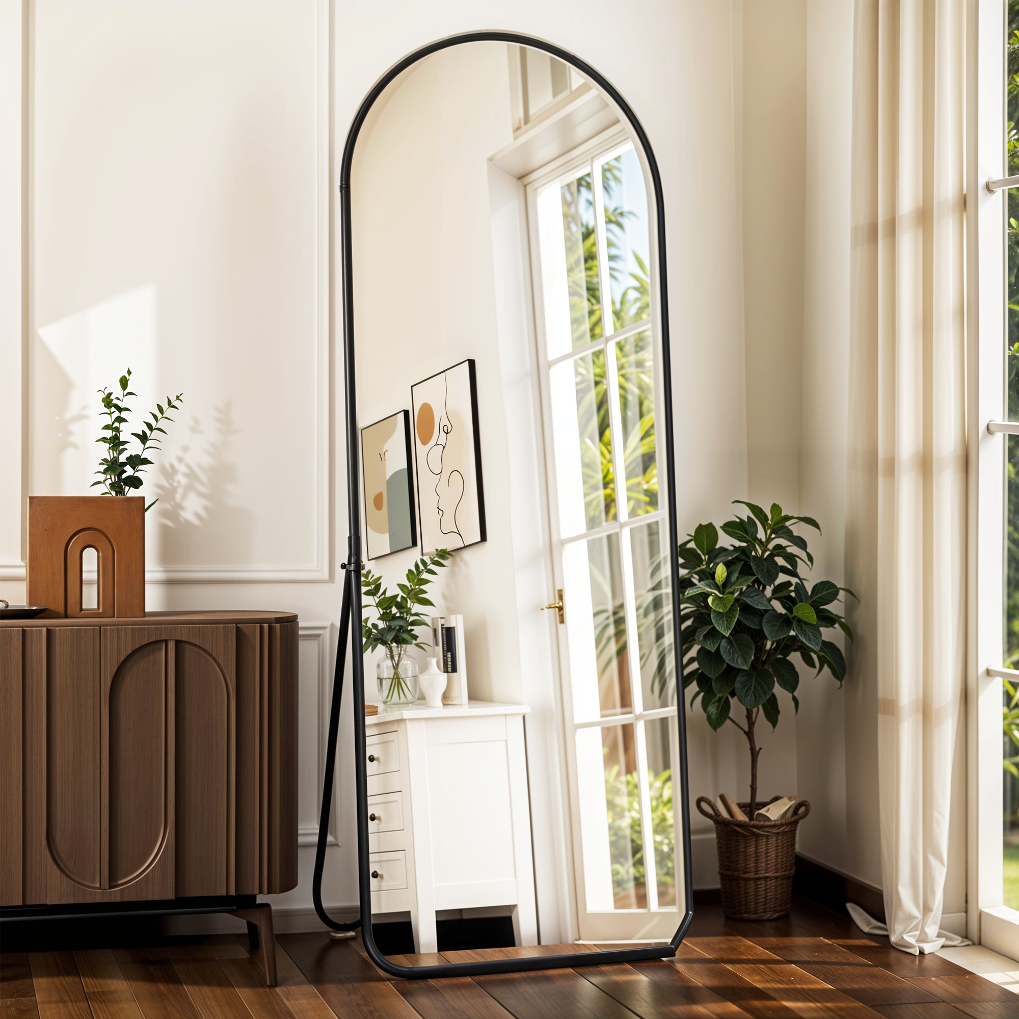 Tall arched mirror reflecting window and plant