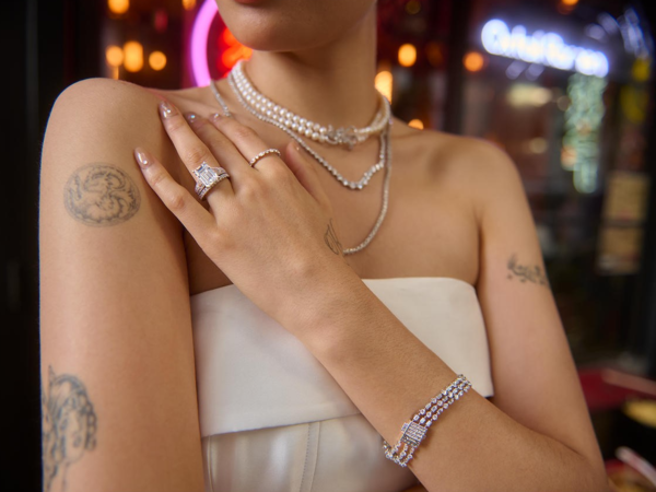 Woman wearing pearl necklaces and diamond jewelry with tattoos