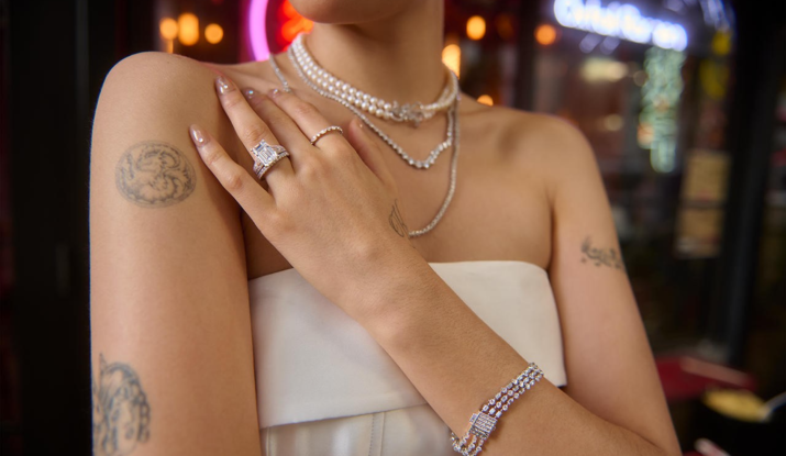 Woman wearing pearl necklaces and diamond jewelry with tattoos