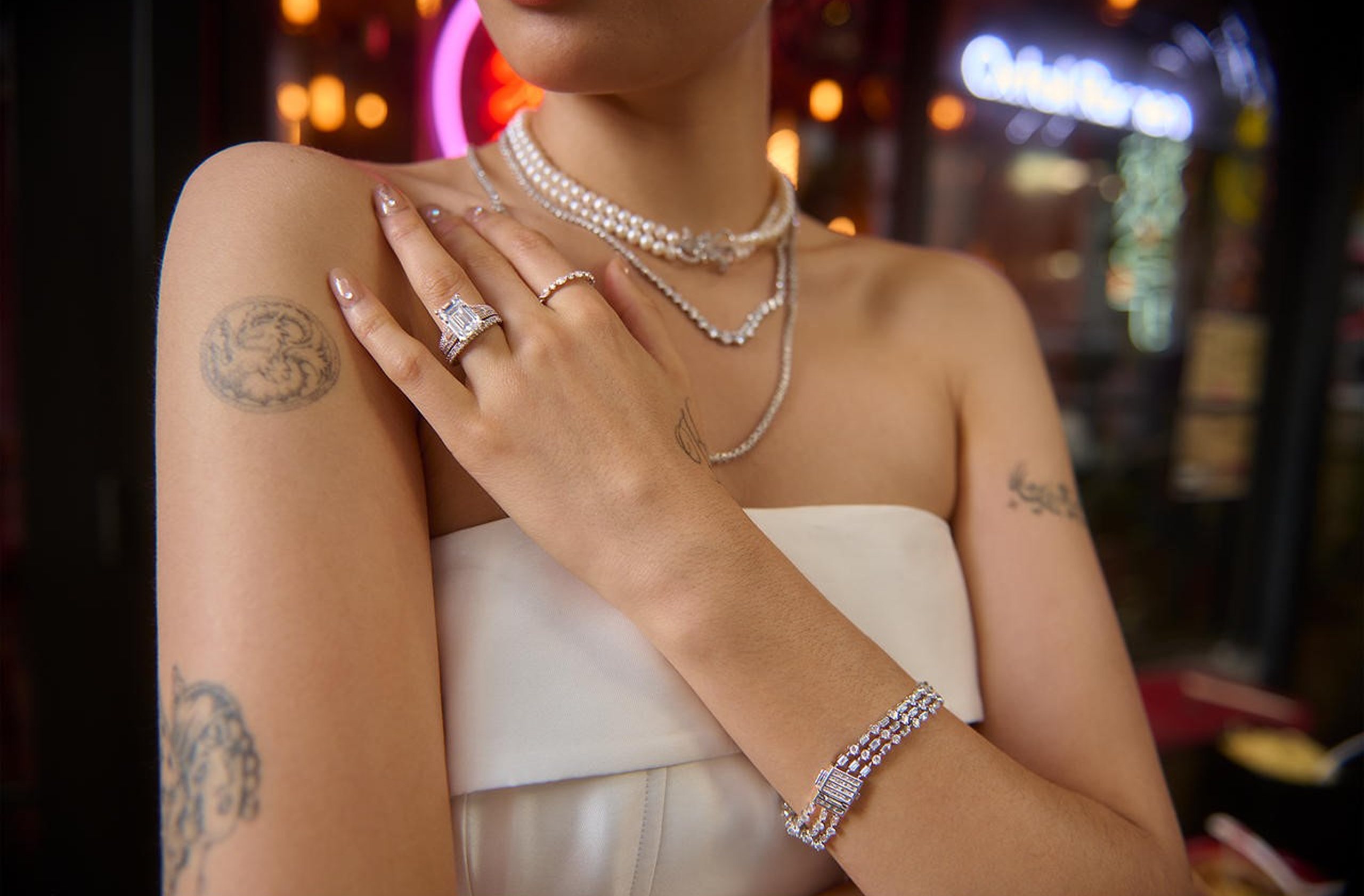 Woman wearing pearl necklaces and diamond jewelry with tattoos