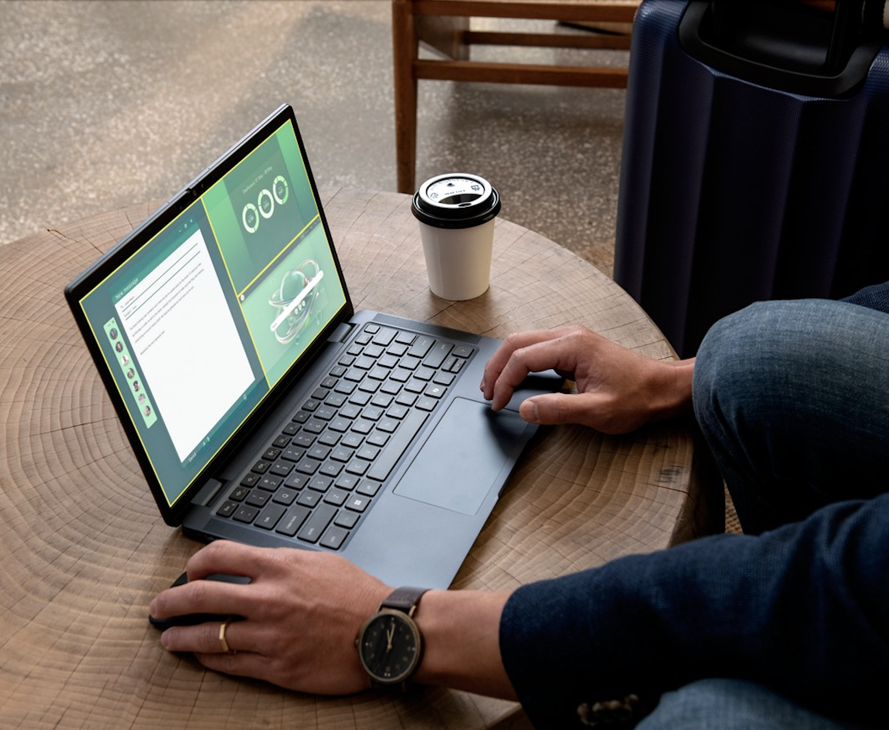 Person using laptop on wooden table with coffee