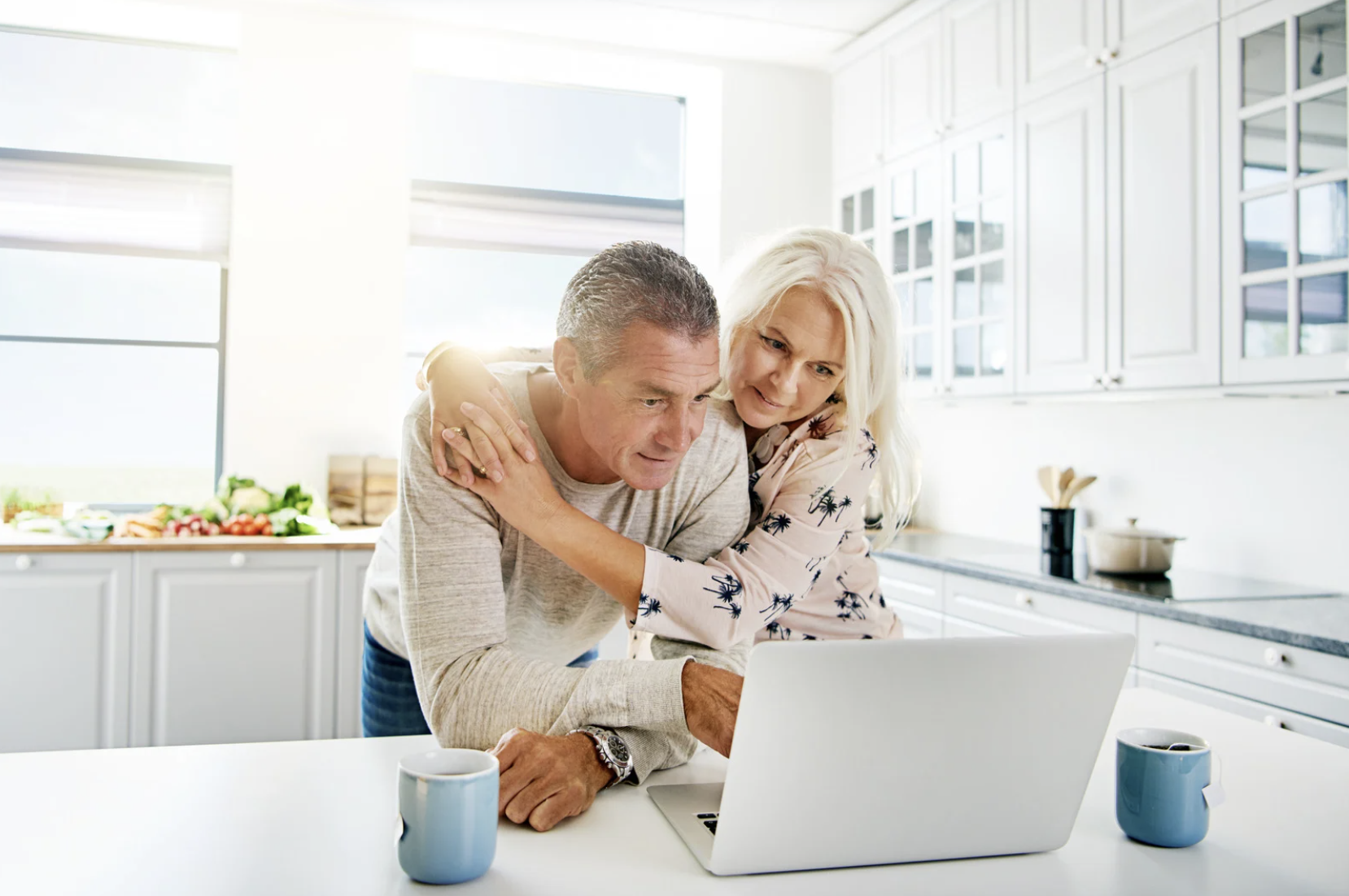 Couple using laptop together in bright kitchen