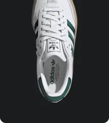 Top view of white Adidas sneaker with green stripes
