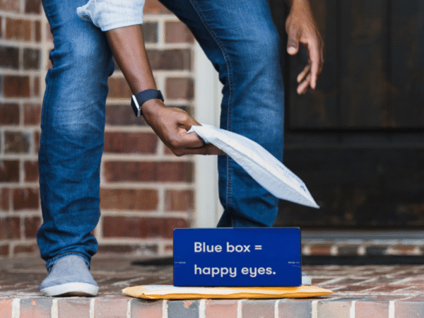 Person picking up packages from doorstep with blue box