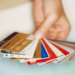 Hand holding multiple credit and membership cards