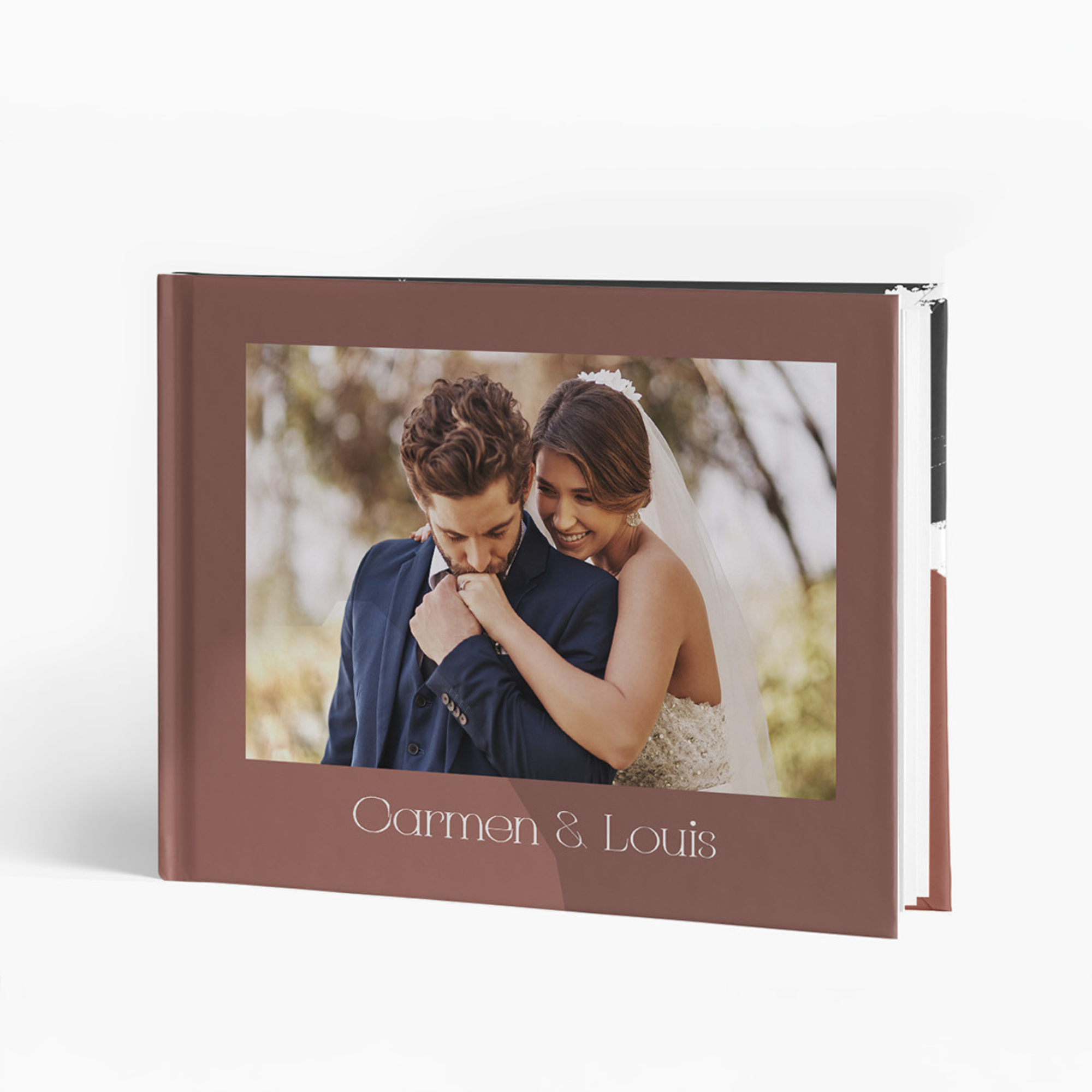 Closed wedding photo album with a brown cover featuring a photograph of a bride and groom embracing, with the names Carmen & Louis printed below the photo.