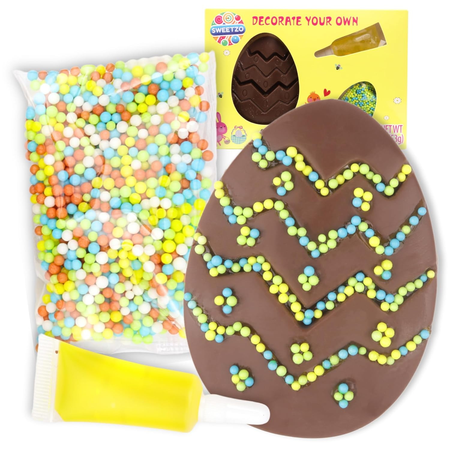 Chocolate egg decorated with yellow, blue, and green candy sprinkles, accompanied by a packet of colorful round sprinkles and a tube of yellow icing, with packaging labeled 'Sweetzo Decorate Your Own' in the background.
