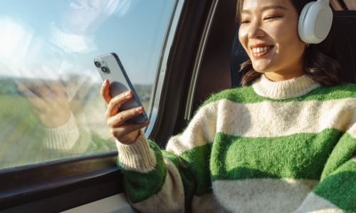 Smiling woman listening to headphones on train journey